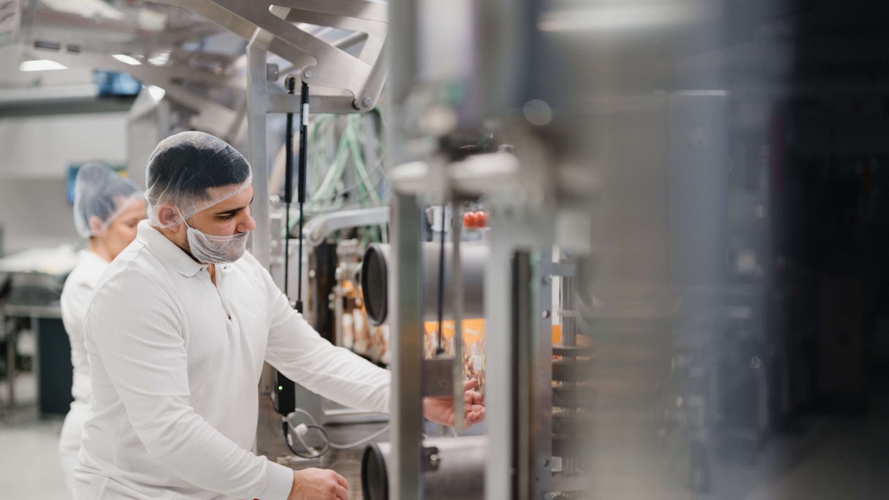 A factory floor with machinery and workers operating the equipment. 