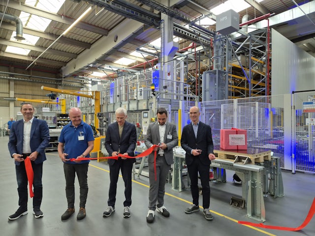 A ribbon cutting ceremony in a factory.