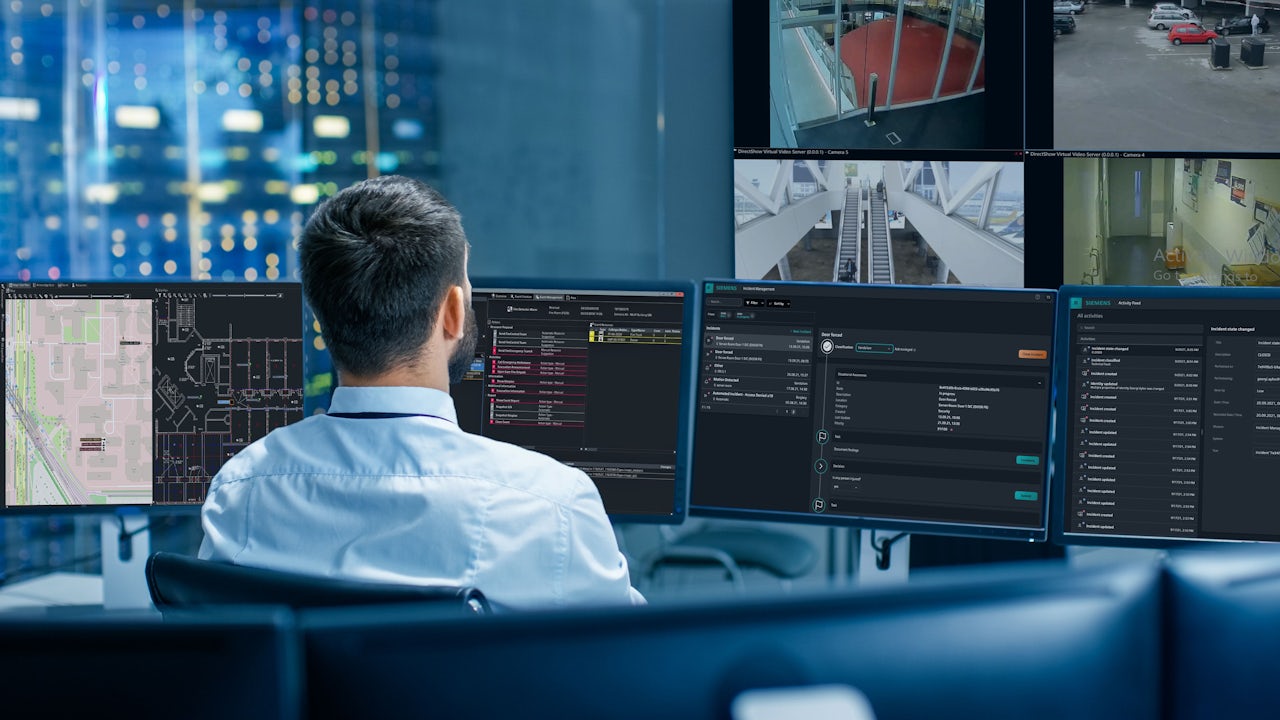Man works in front of multiple computer monitors