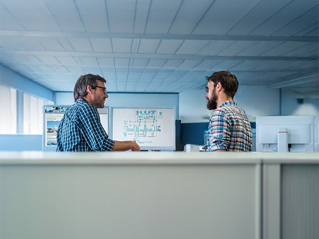 Two people working together looking at a computer screen with visualisation of water systems.