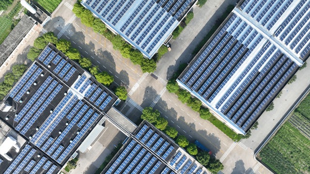 Aerial view of battery manufacturing facility with robotic arms and conveyor belts