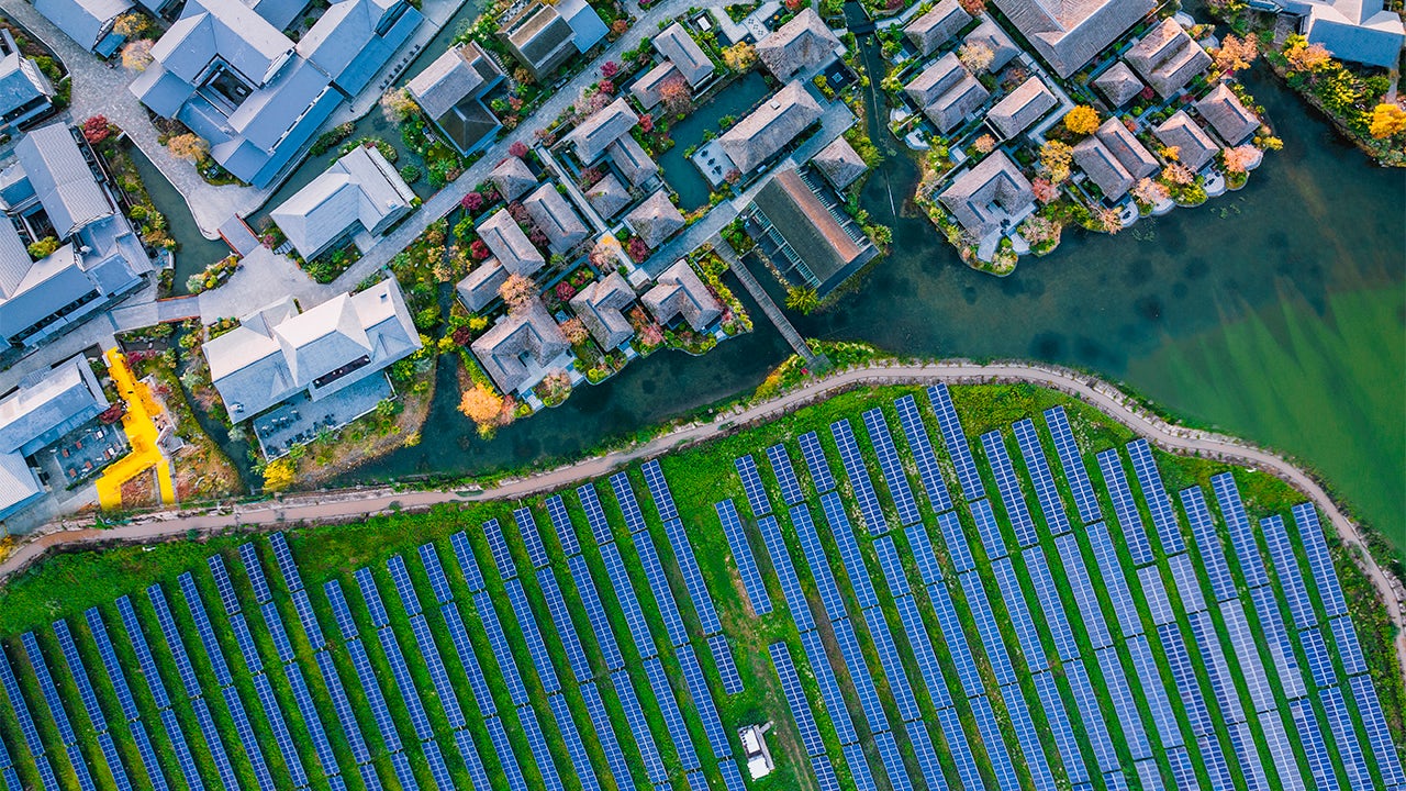 The image shows a solar power plant with multiple solar panels installed on a field.