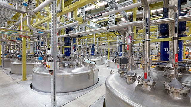 Laboratory glassware with colorful liquids on a reflective surface