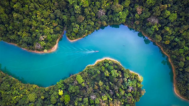 Image of a blue river with a boat moving through it.