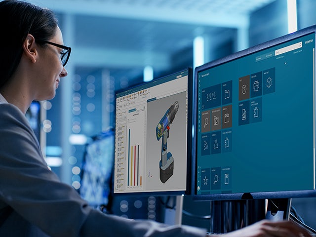 A woman looks at a computer monitor