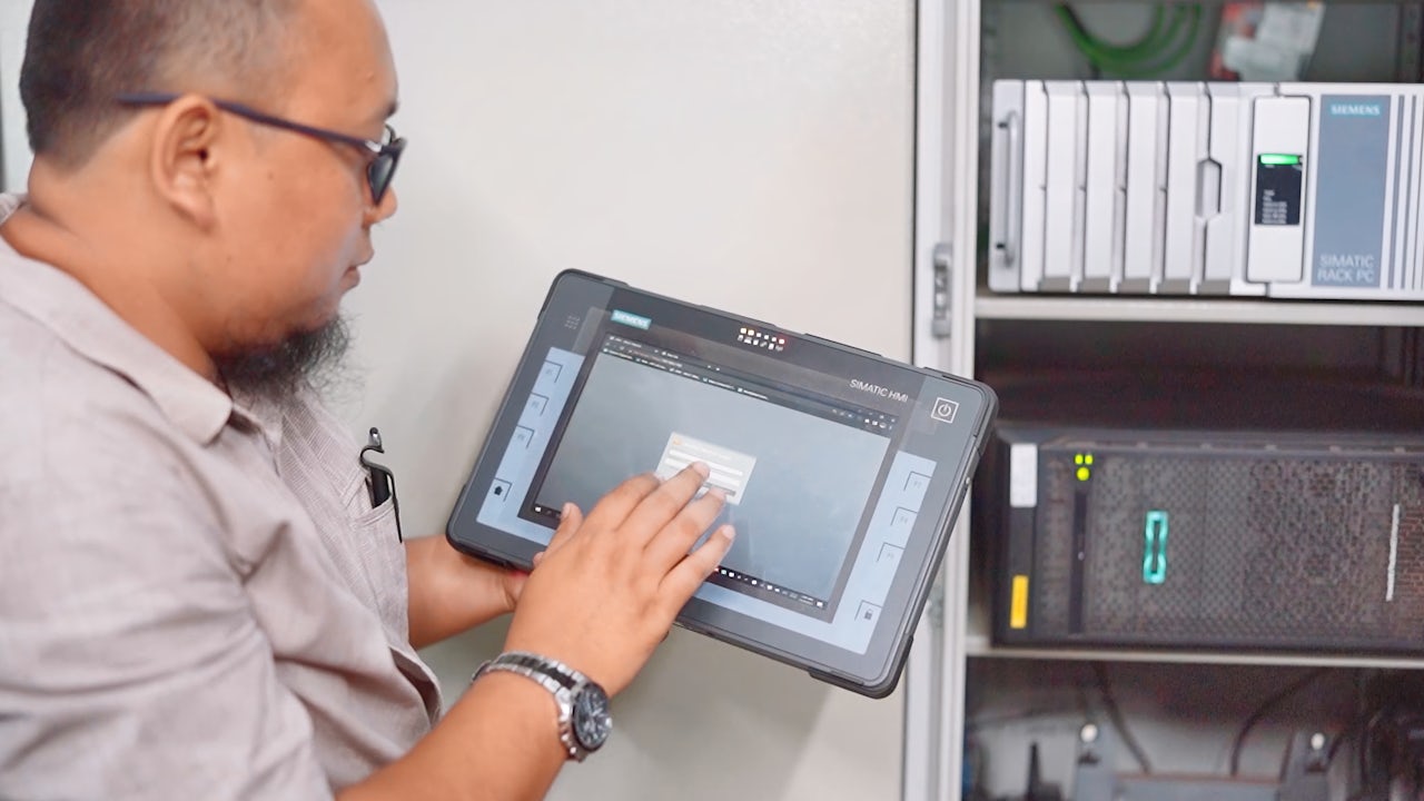 A man presses a button on the screen of a tablet.